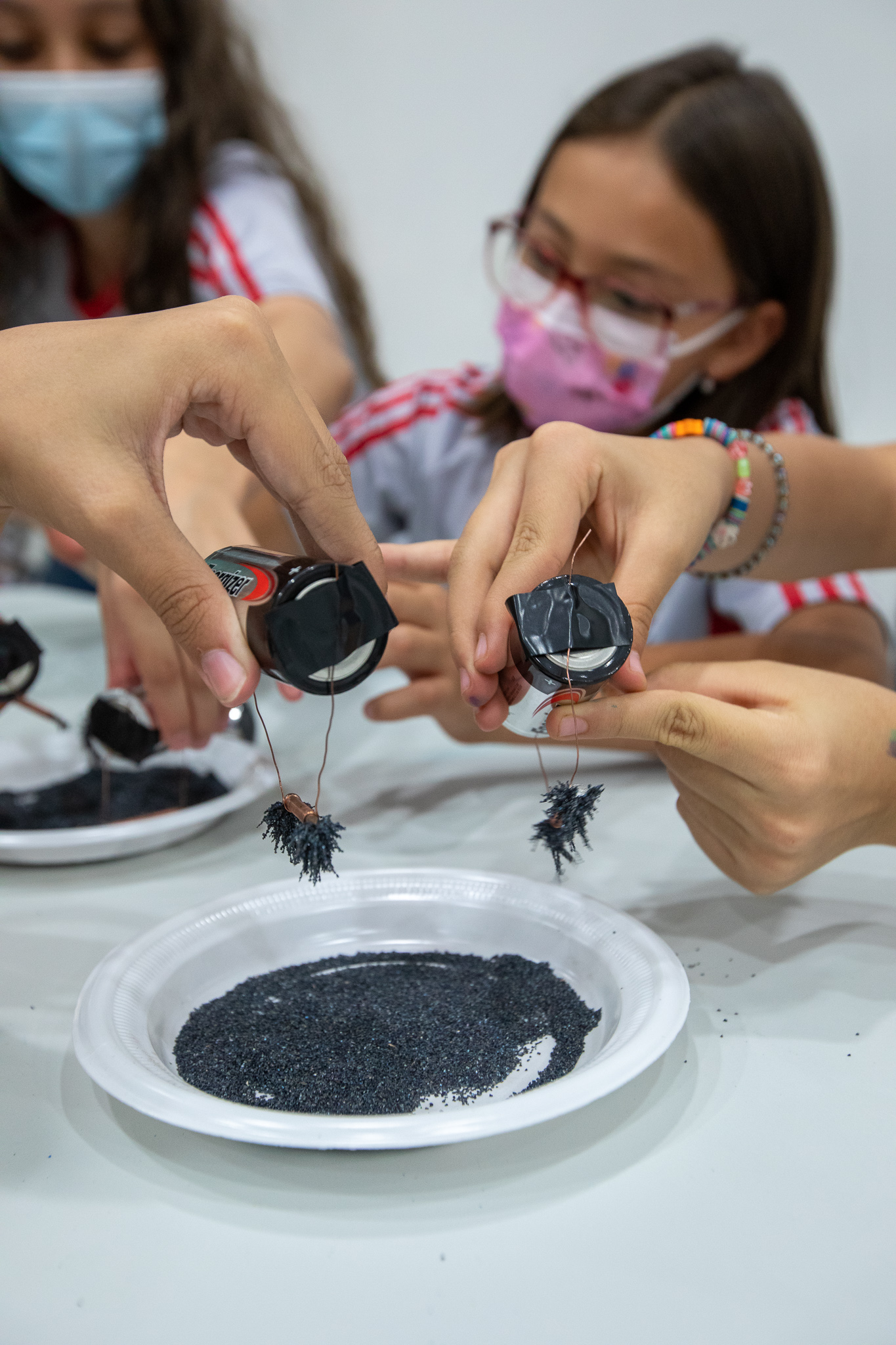 Niños haciendo experimento de atracción de la energía