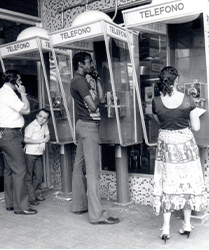 Personas hablando por teléfonos públicos 